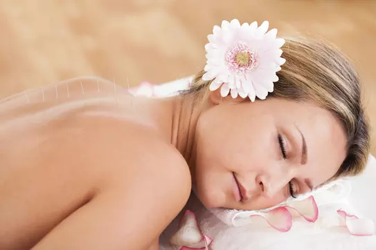 Woman relaxing with flower in hair.